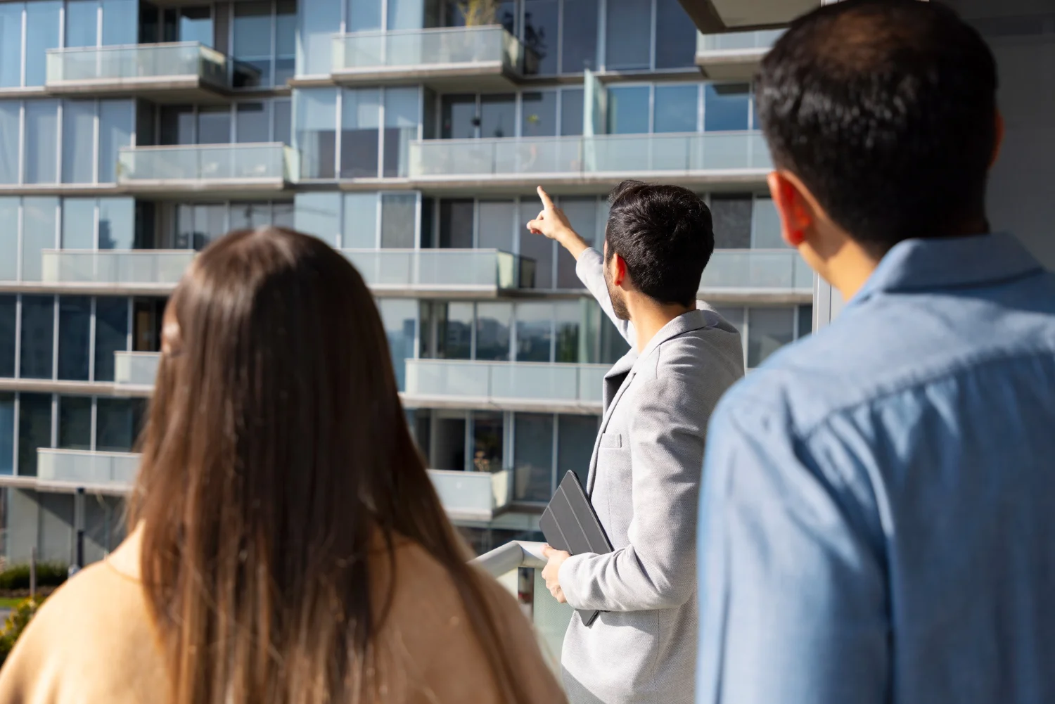 Hombre mostrando edificio a una pareja